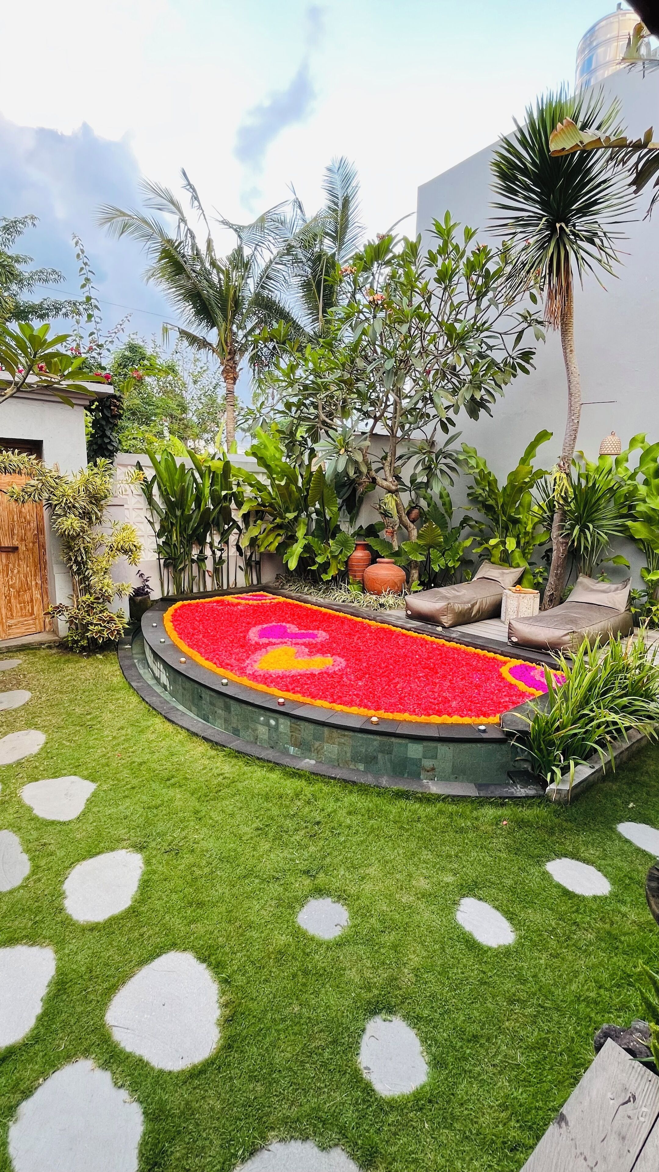 Un jardín circular con un parterre, palmeras y una zona de estar.