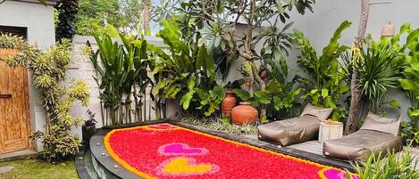 Un jardín circular con un parterre, palmeras y una zona de estar.