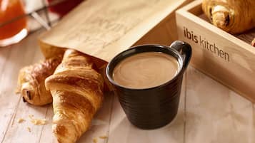Una bandeja de madera con croissants y una taza de café.