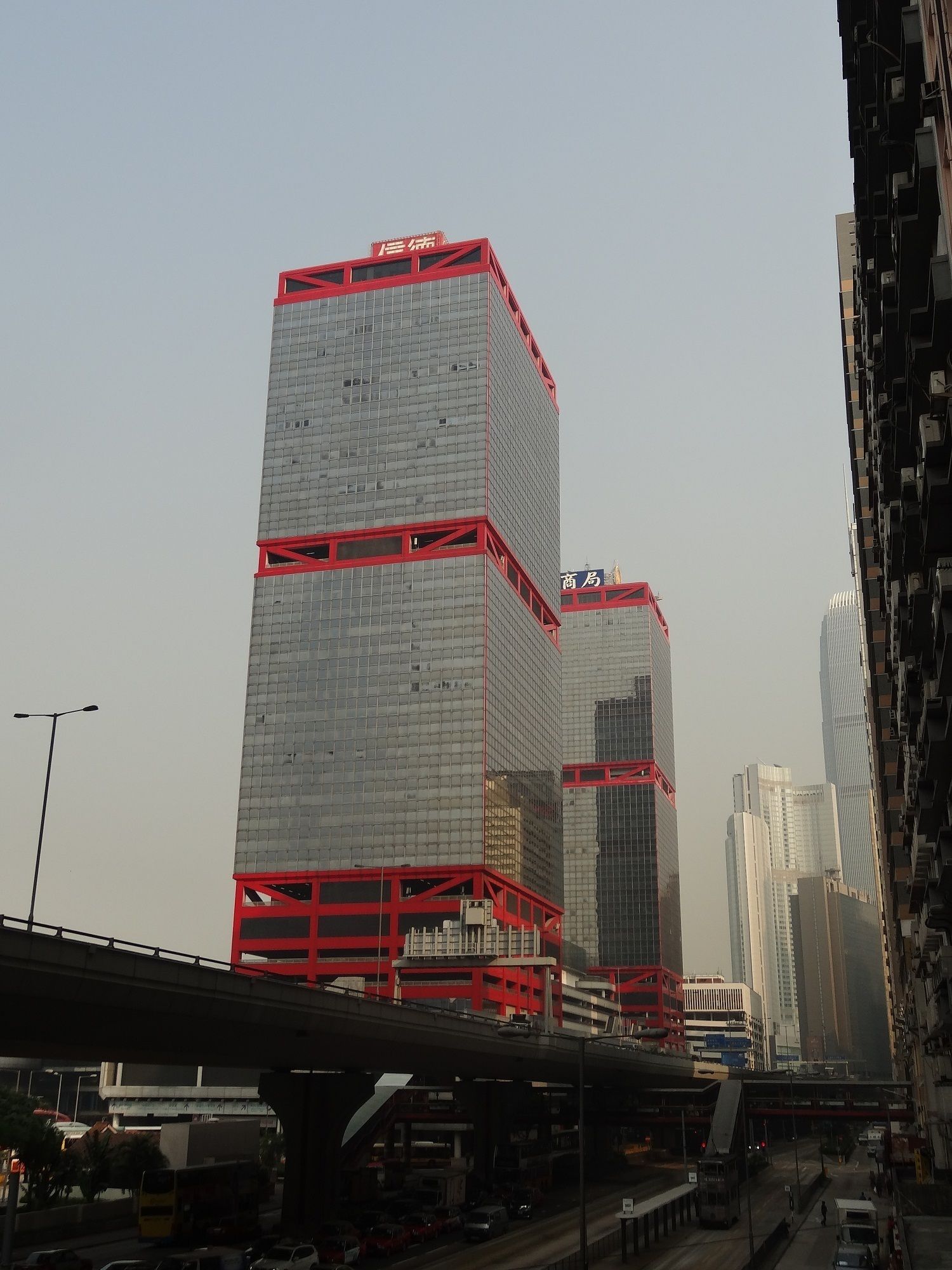 A multi-story building with a red structural framework and a glass facade.