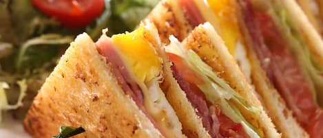 A sandwich cut into triangles, accompanied by a side salad and fries.