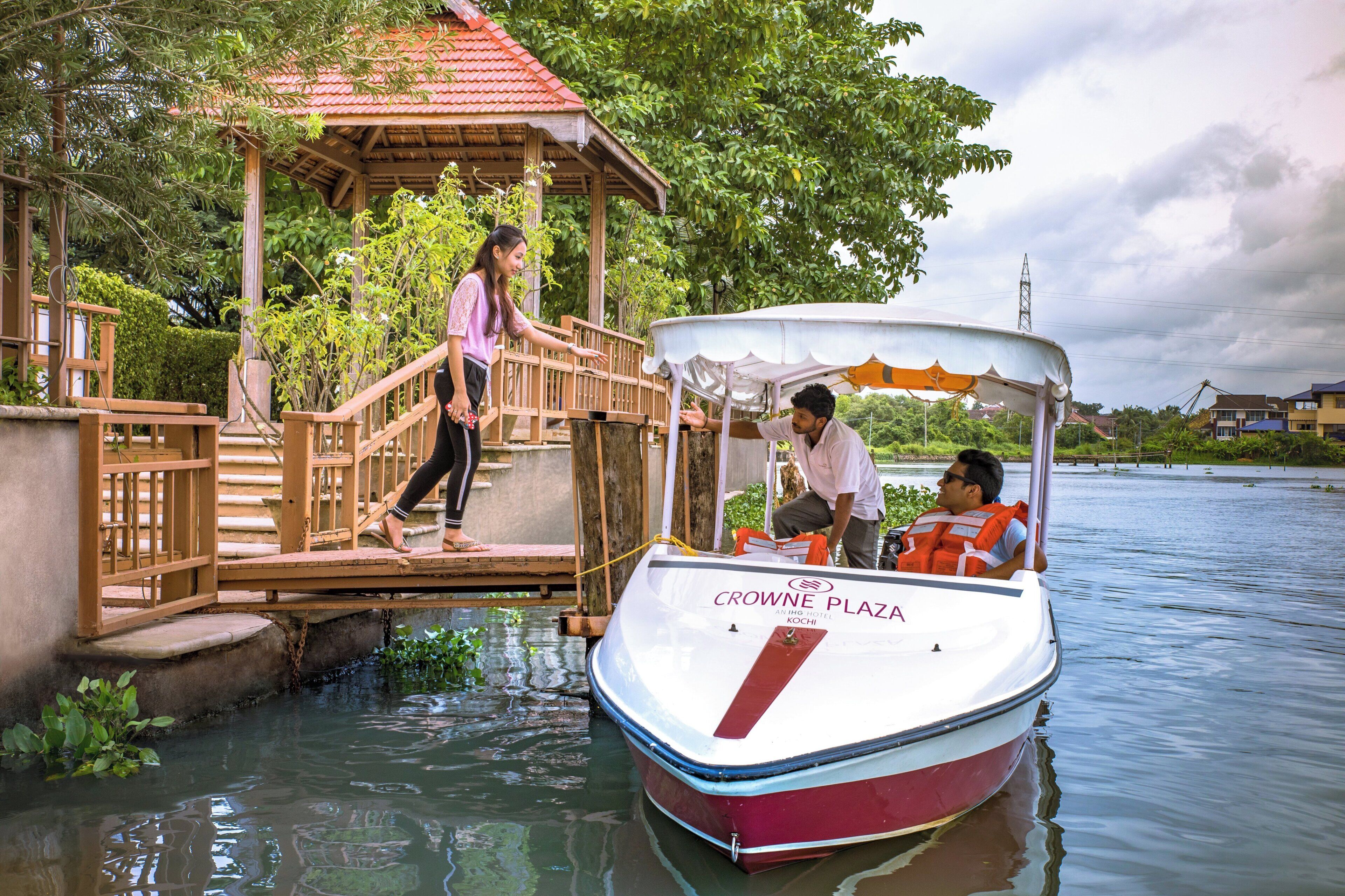 Un bateau était amarré à un quai en bois, doté d’un espace de repos abrité, d’un pont en bois et, en arrière-plan, d’une végétation luxuriante.