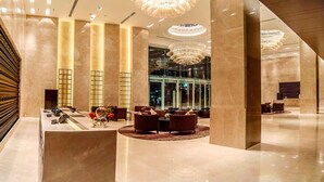 A spacious lobby with marble flooring, large chandeliers, and modern seating areas. - Crowne Plaza Kochi by IHG (Kanayannur)
