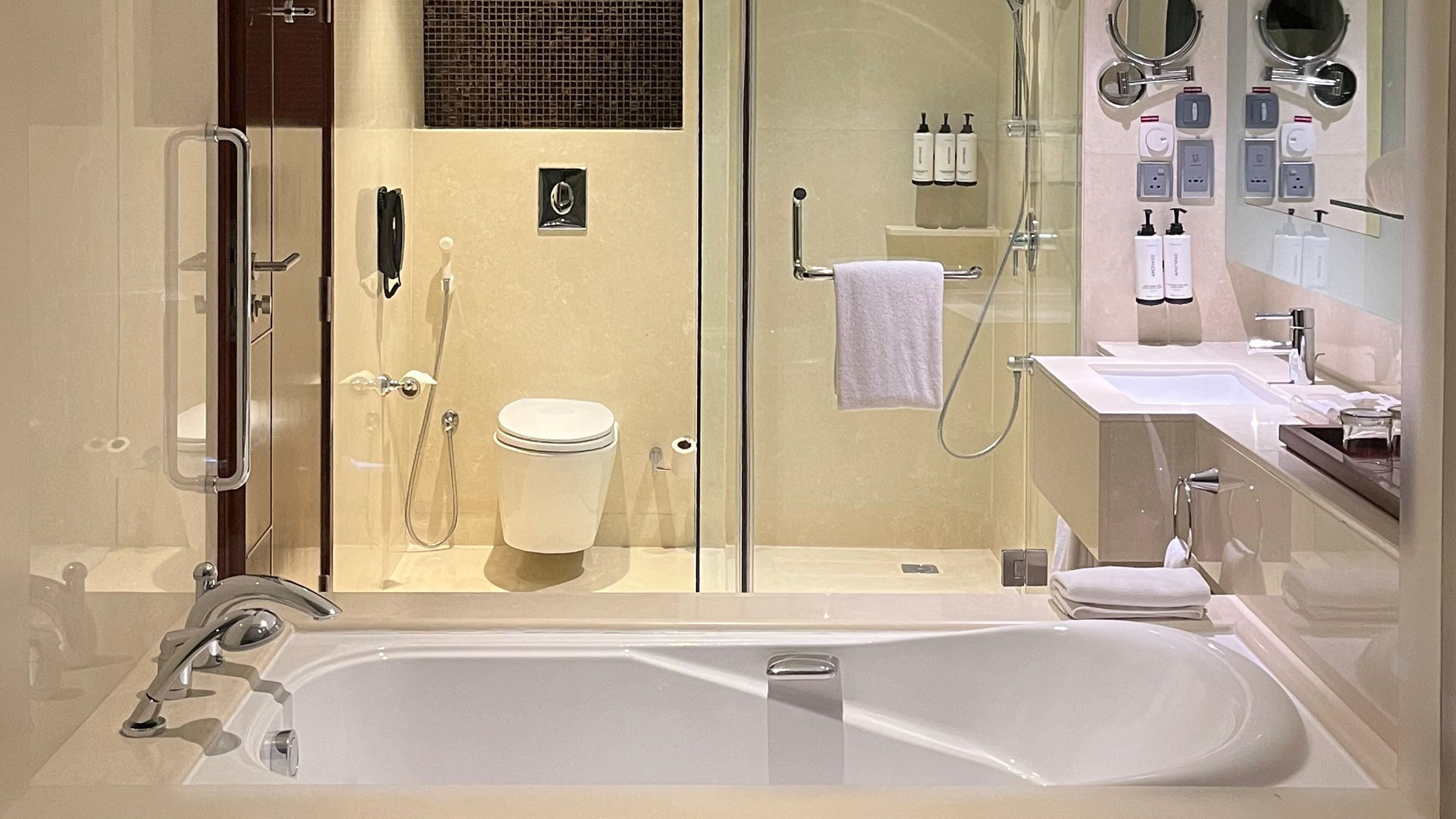 Une salle de bain moderne avec une douche à parois de verre, une baignoire et des toilettes.