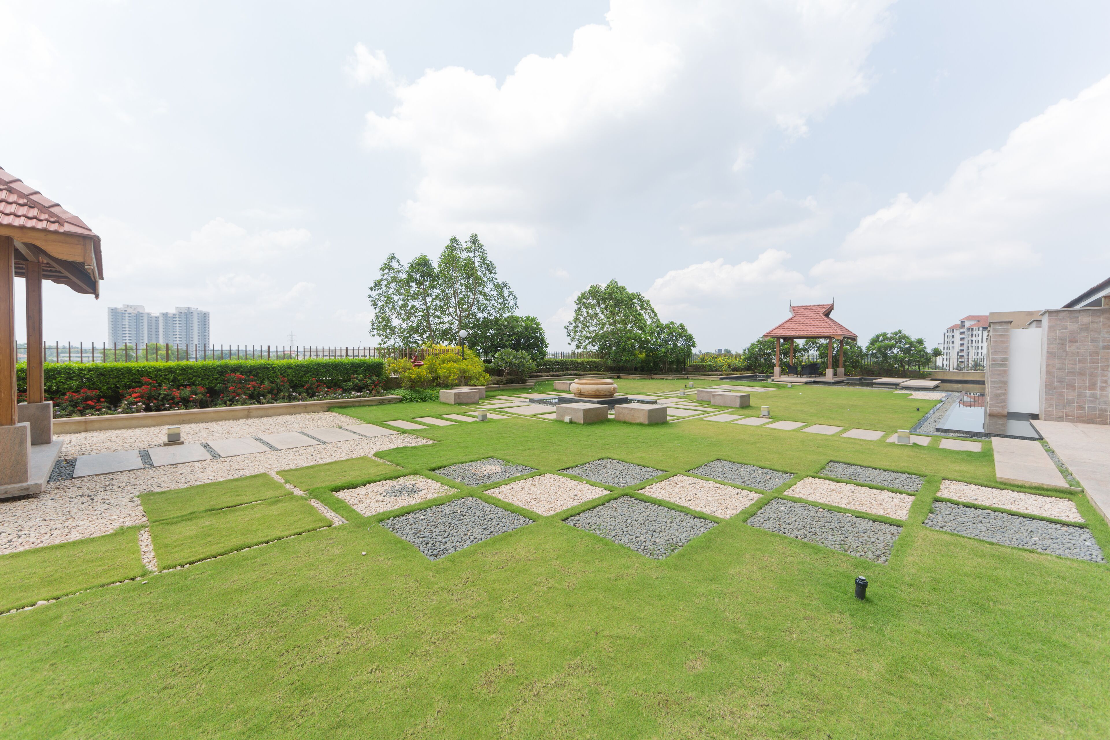 A landscaped garden with a gazebo, seating areas, and a water feature.
