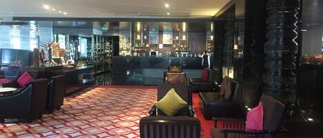 A modern bar area with seating and a patterned carpet.