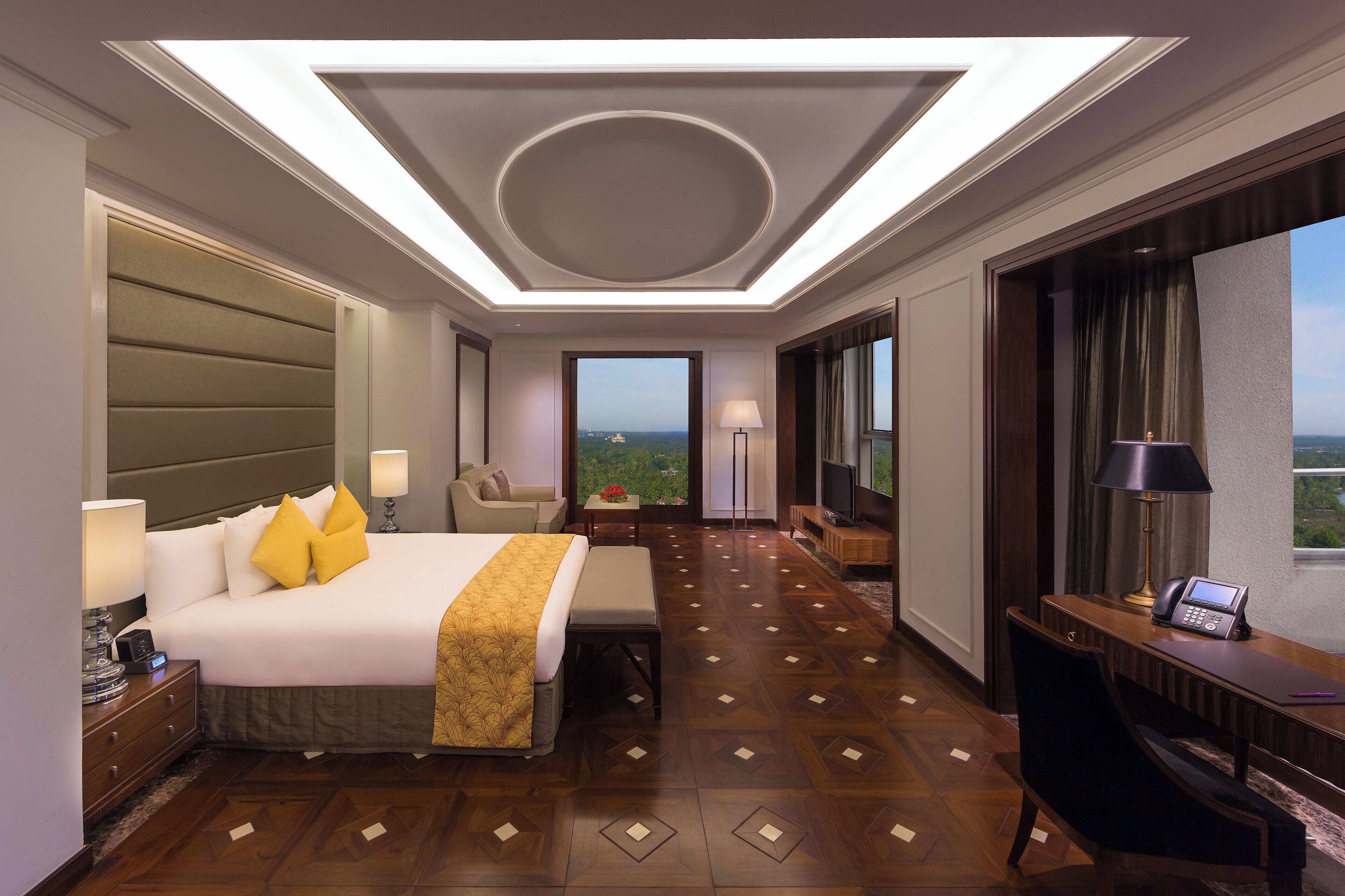 Une chambre d’hôtel avec un grand lit, un bureau, une chaise, une télévision et une vue sur l’extérieur.