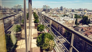 Vista da cidade a partir de um edifício alto, com céu claro.