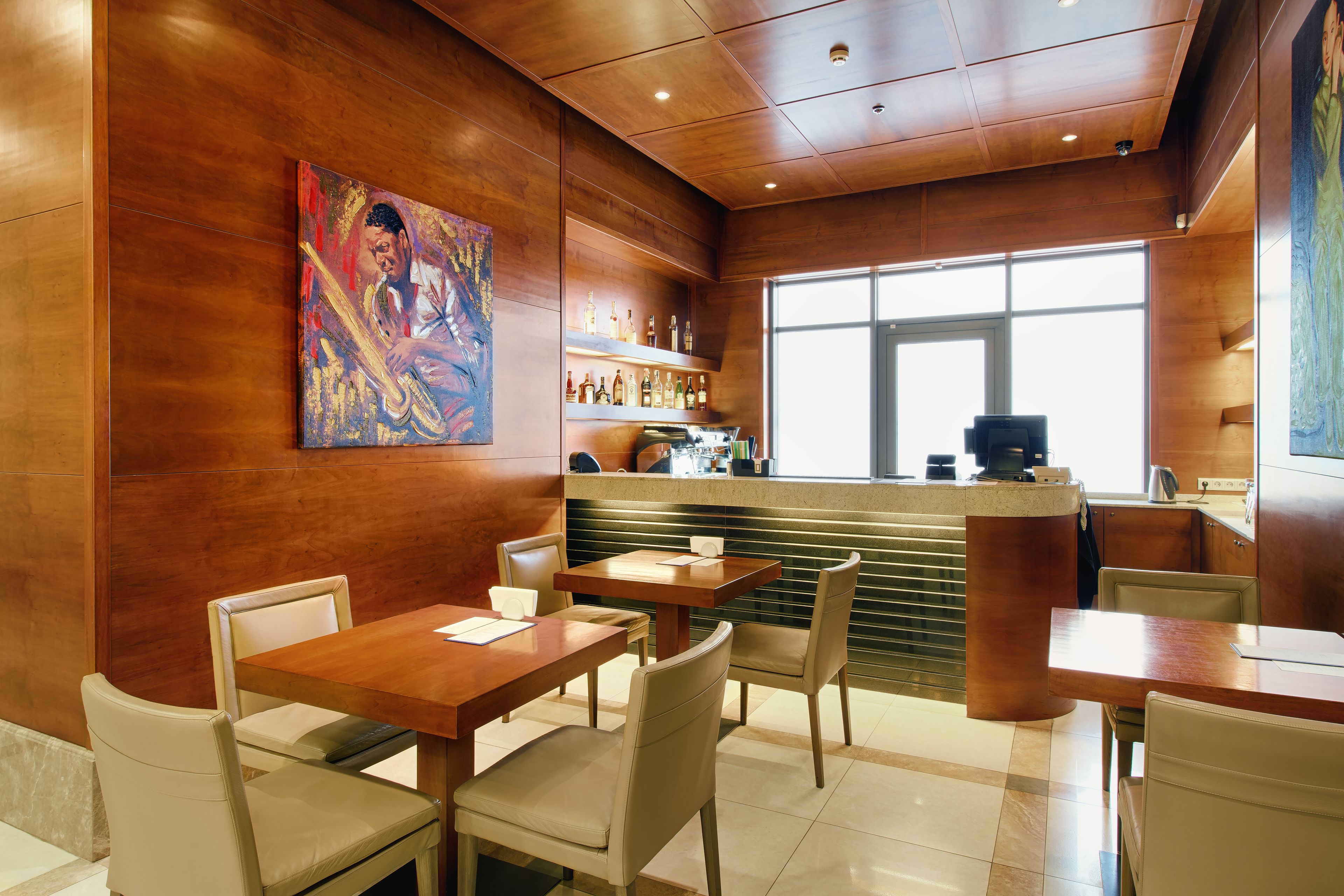 L'intérieur d'un restaurant avec des murs en bois, un comptoir et des tables pour les clients.