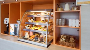 Una presentación de desayuno con distintos alimentos y una máquina de café.