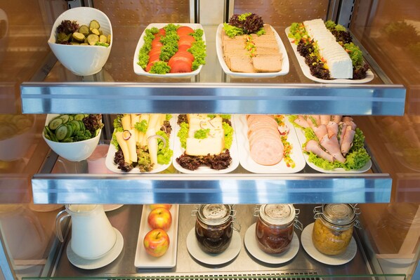 A buffet with various food items including salads, sandwiches, and fruits.