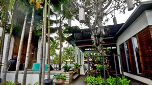 A modern house with a wooden deck, outdoor seating, and tropical plants. - Paragon Inn (Bang Phli)