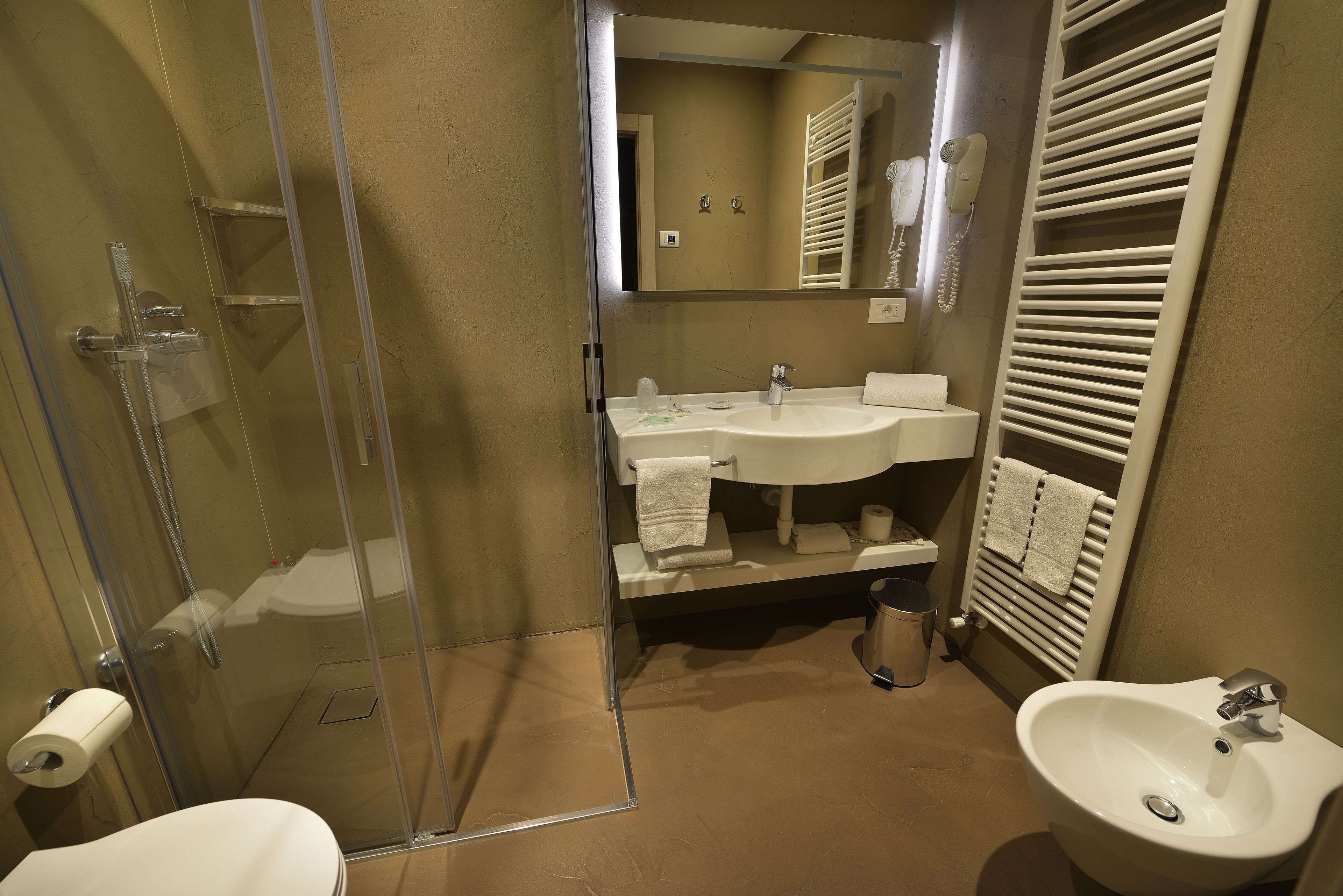 Ein Badezimmer mit einer Duschkabine, einem Waschbecken und einem Bidet.