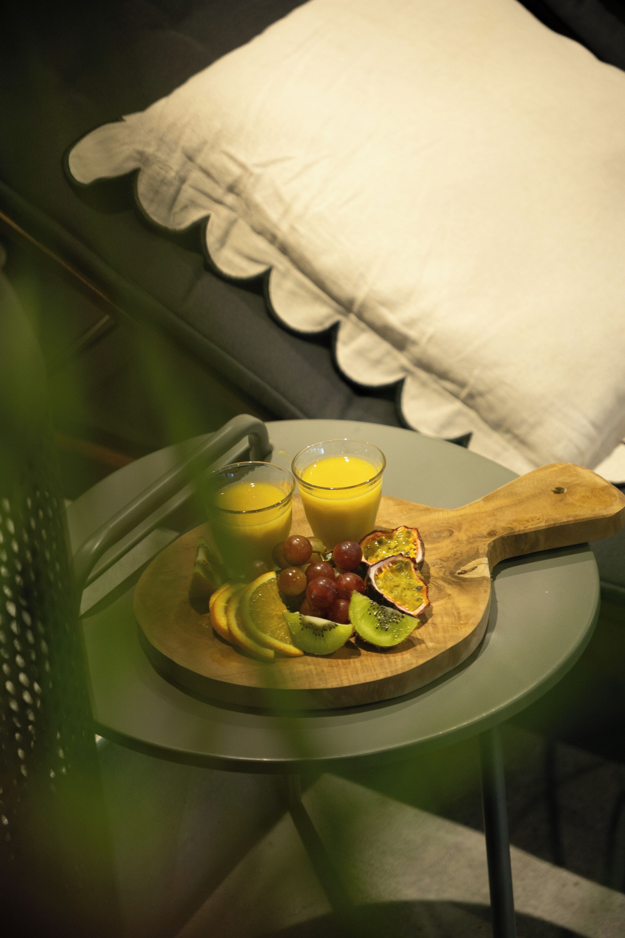 En bakke med frugt og juice på et lille bord.