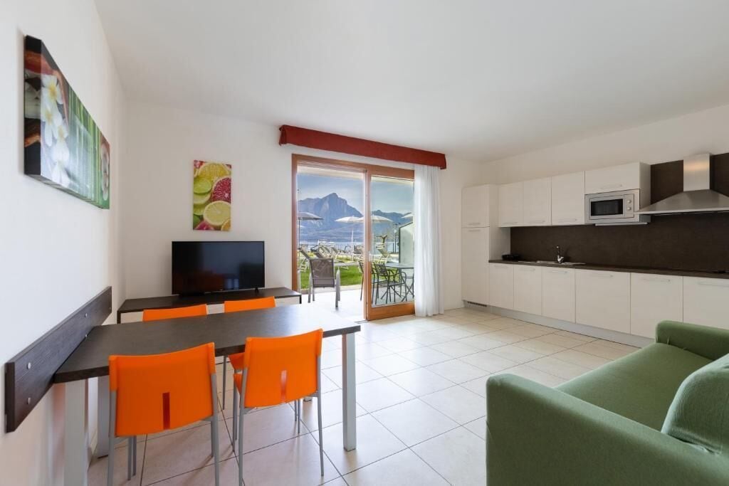 A modern kitchen with white cabinets, a microwave, and a large window overlooking a scenic view.