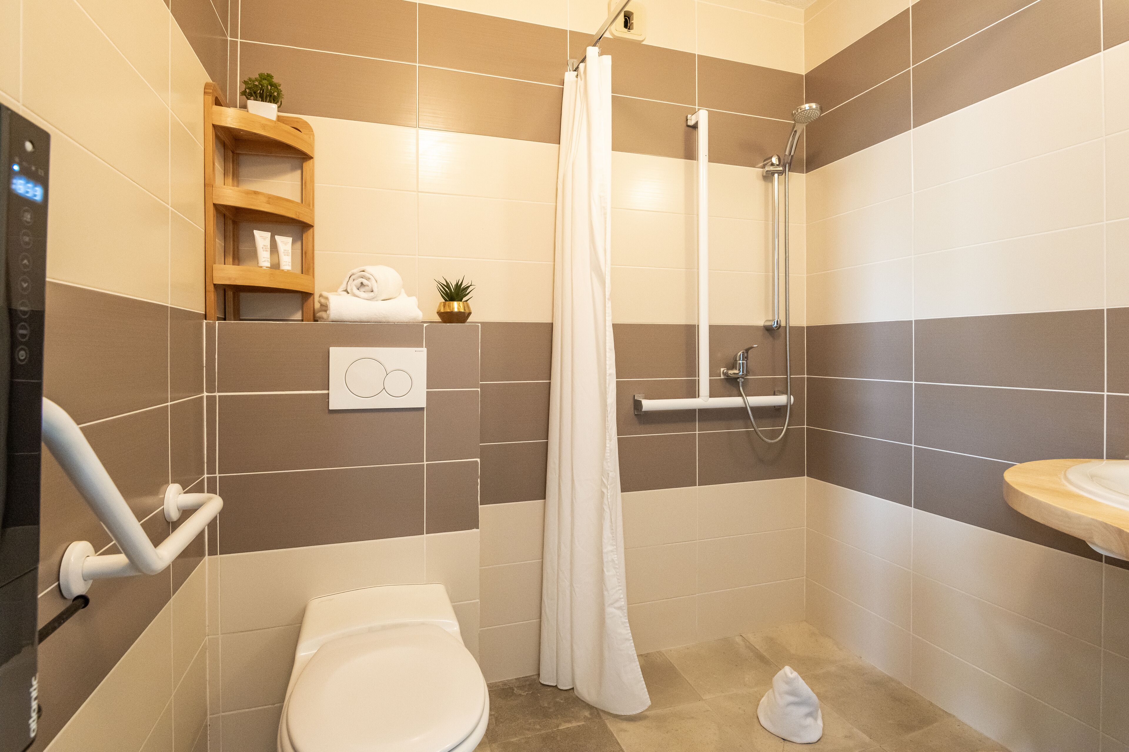 A modern bathroom with a shower, toilet, and sink.