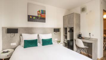 Una habitación de hotel moderna con una cama grande, dos mesitas de noche, un escritorio con silla y un armario.