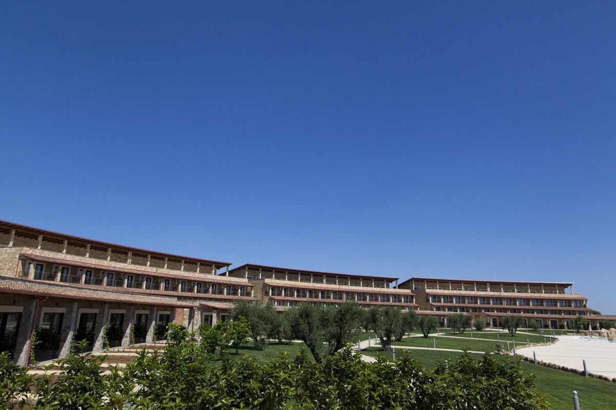 A large, multi-story building with a flat roof and a series of balconies.