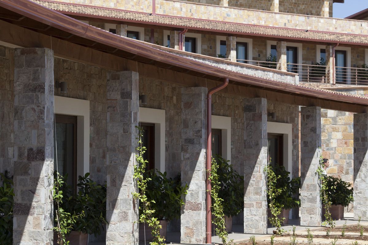 A stone building with multiple balconies and potted plants.