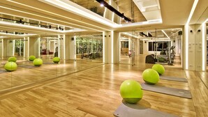 A spacious gym with wooden floors, exercise balls, and yoga mats. - Ortaköy Aparts (Istanbul)