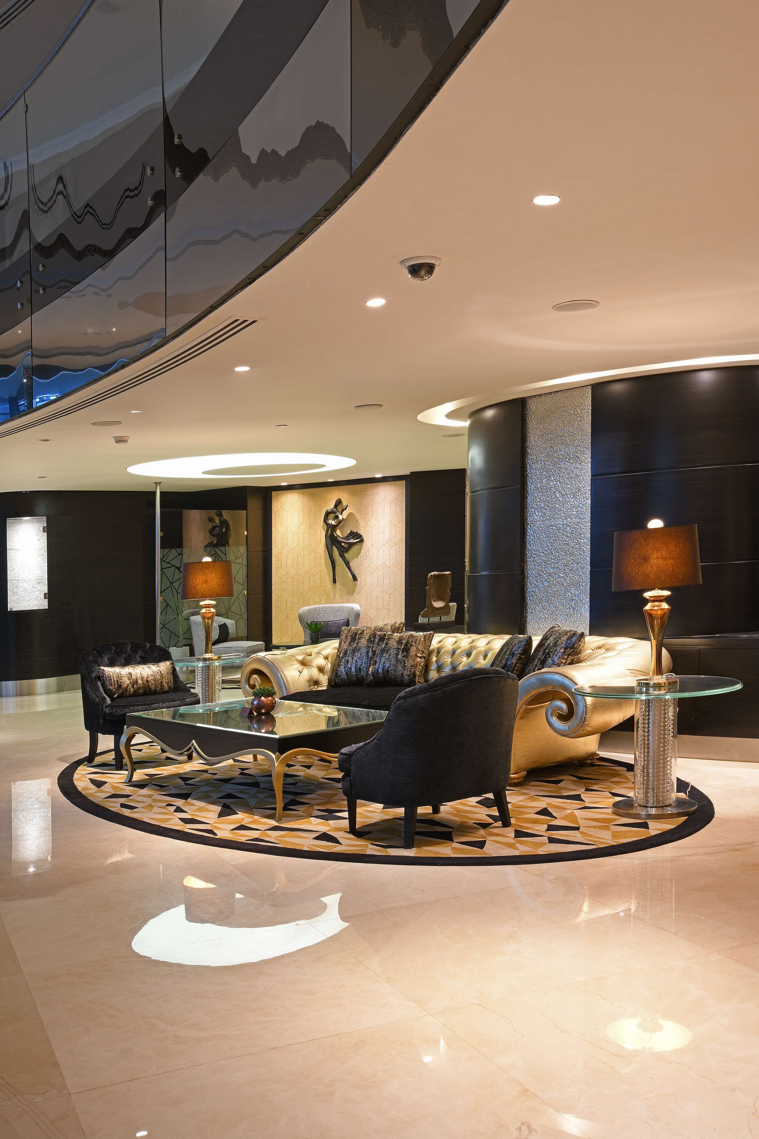 A modern lobby with a plush sofa, a glass coffee table, and a patterned rug.