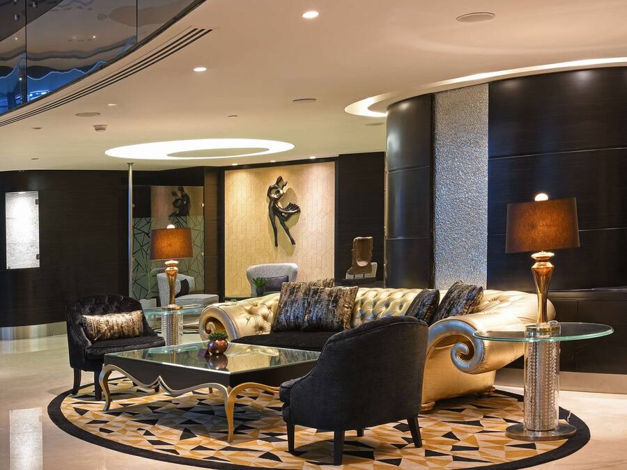 A modern lobby with a plush sofa, a glass coffee table, and a patterned rug.