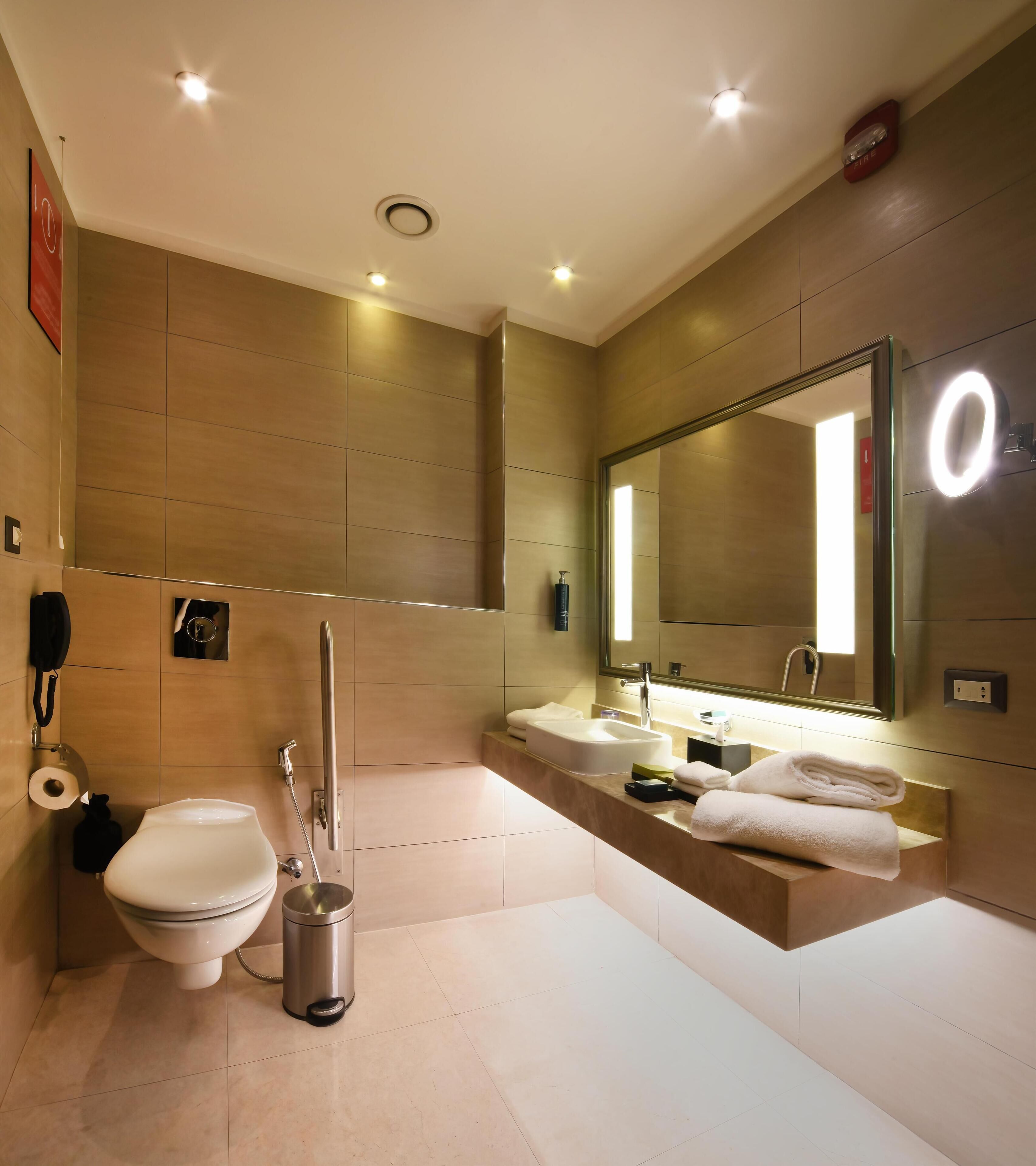 Un baño moderno con inodoro, bidé y tocador con espejo.