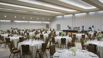Un amplio salón de banquetes con mesas redondas dispuestas en filas para comedor.