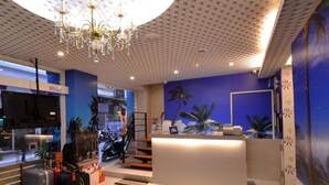A hotel lobby with a reception desk, a staircase, and luggage. - Happiness Inn (Taipei)