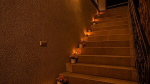 Una escalera con escalones iluminados por una luz cálida, cada uno decorado con pequeñas macetas.