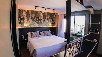 Quarto moderno com uma cama grande, uma TV e uma parede decorativa.