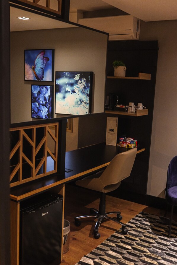 A modern office space with a desk, chair, and decorative wall art.