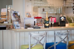 Una zona de bar con una botella de champán, copas y un libro titulado "GOLVEN".