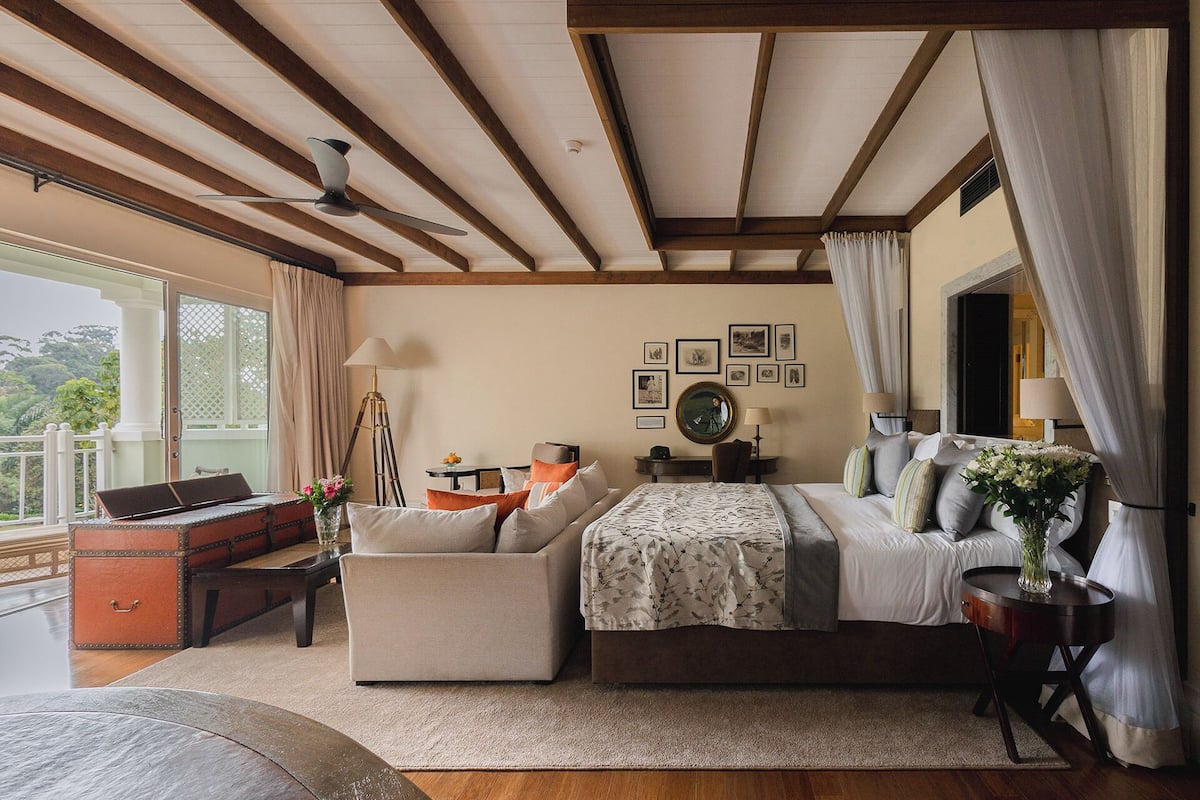 Une chambre avec un lit, un canapé, un bureau et un balcon.