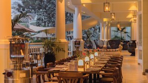 A restaurant with a long dining table, chairs, and hanging lights. - Hemingways Nairobi (Nairobi)