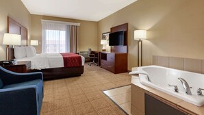 A hotel room with a bed, desk, chair, TV, and a large bathtub. - Comfort Inn & Suites Page at Lake Powell (Page)