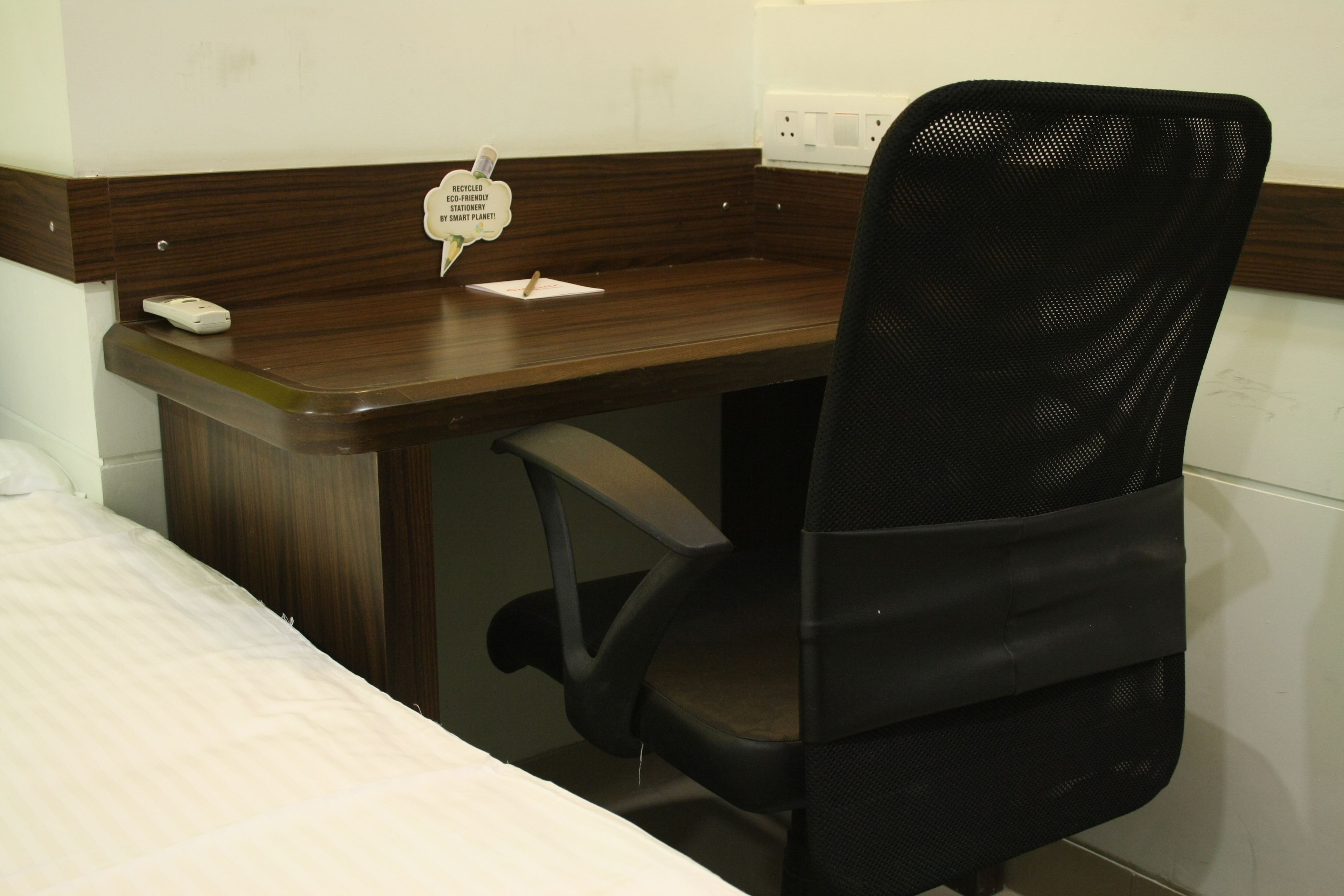 A small office space with a desk, chair, and a bed.