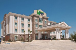Een hotel met een opvallend bord, een overdekte ingang en een parkeerplaats met aangepaste toegankelijkheid.
