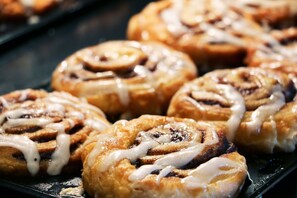 A tray of cinnamon rolls with icing.