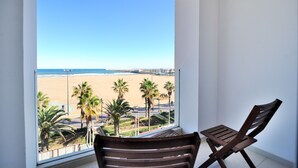 A balcony with a view of a beach, palm trees, and a clear sky. - Hotel Boutique Sabbia Valencia (Valencia)