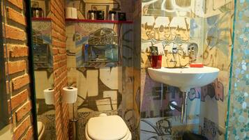 Une salle de bain avec des toilettes, un lavabo et une cloison en verre.