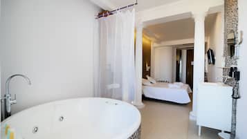 Un baño moderno con una bañera amplia, zona de ducha y un inodoro separado.