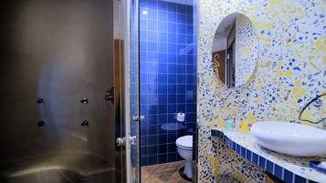 Een badkamer met een douche, toilet en wastafel.