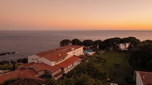 A coastal property with a swimming pool, multiple buildings with red-tiled roofs, and a view of the sea. - Il Santavenere (Maratea)