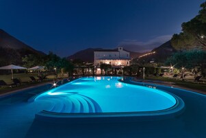 Una piscina al aire libre de temporada, sombrillas