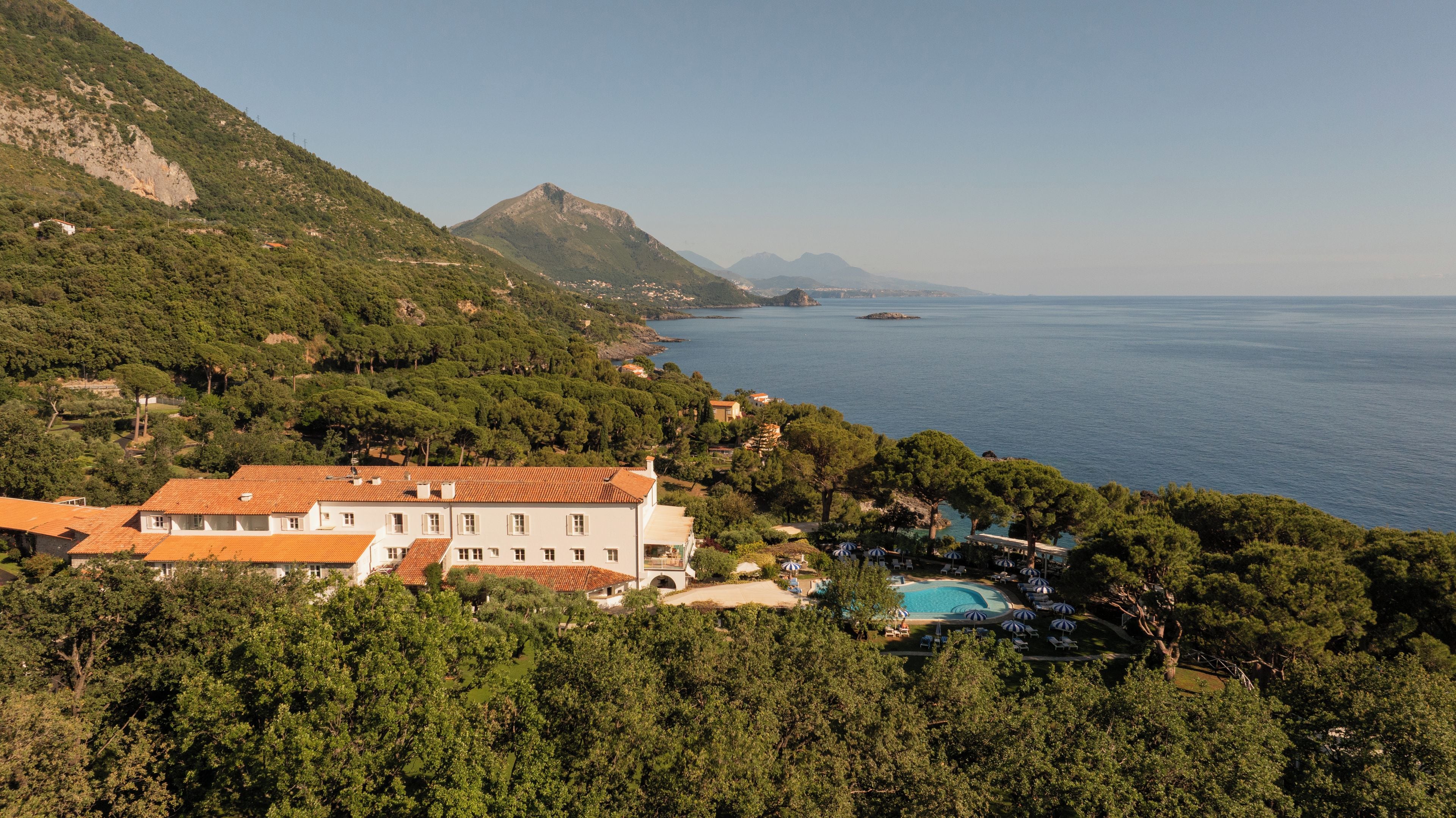 Une propriété située sur la côte, dotée d’une piscine, entourée d’une végétation luxuriante et offrant une vue sur la mer.