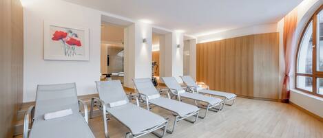 A modern waiting area with lounge chairs, a wooden wall, and a large window.