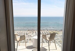 A balcony with a view of a beach, featuring sun loungers and umbrellas. - Daniel's Hotel (Riccione)