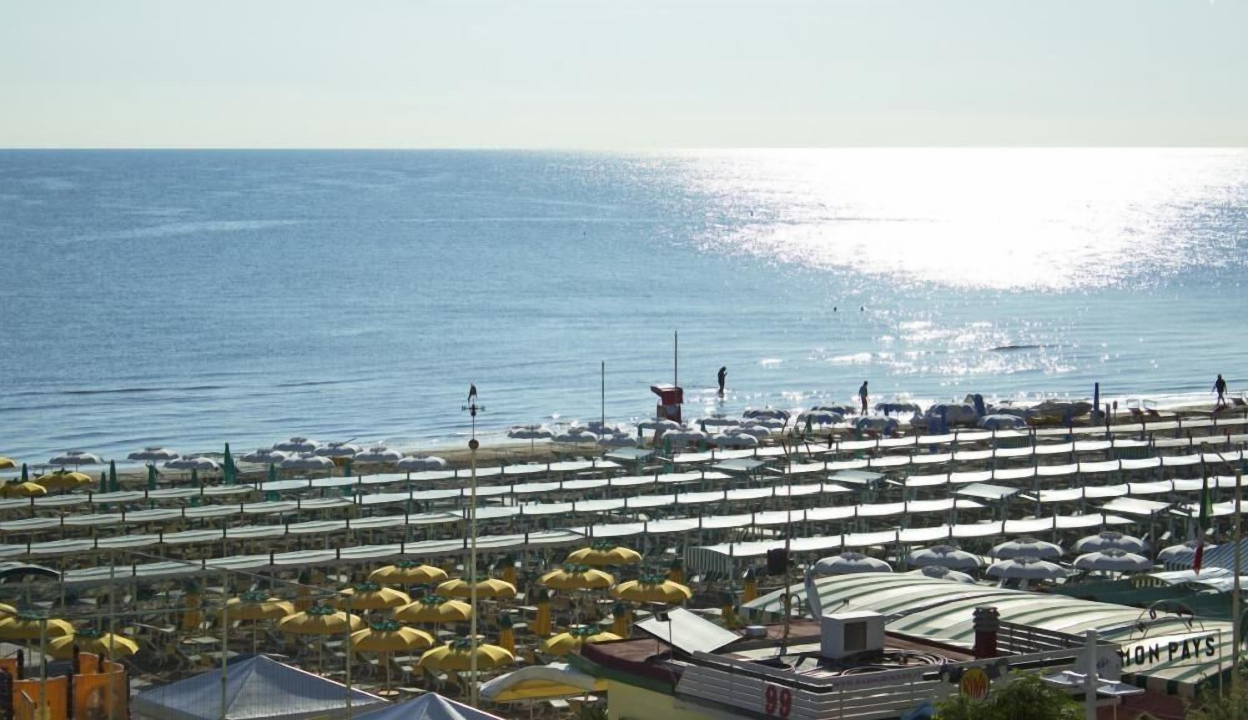 A coastal area with rows of beach umbrellas and a large building labeled "MON PAYS".