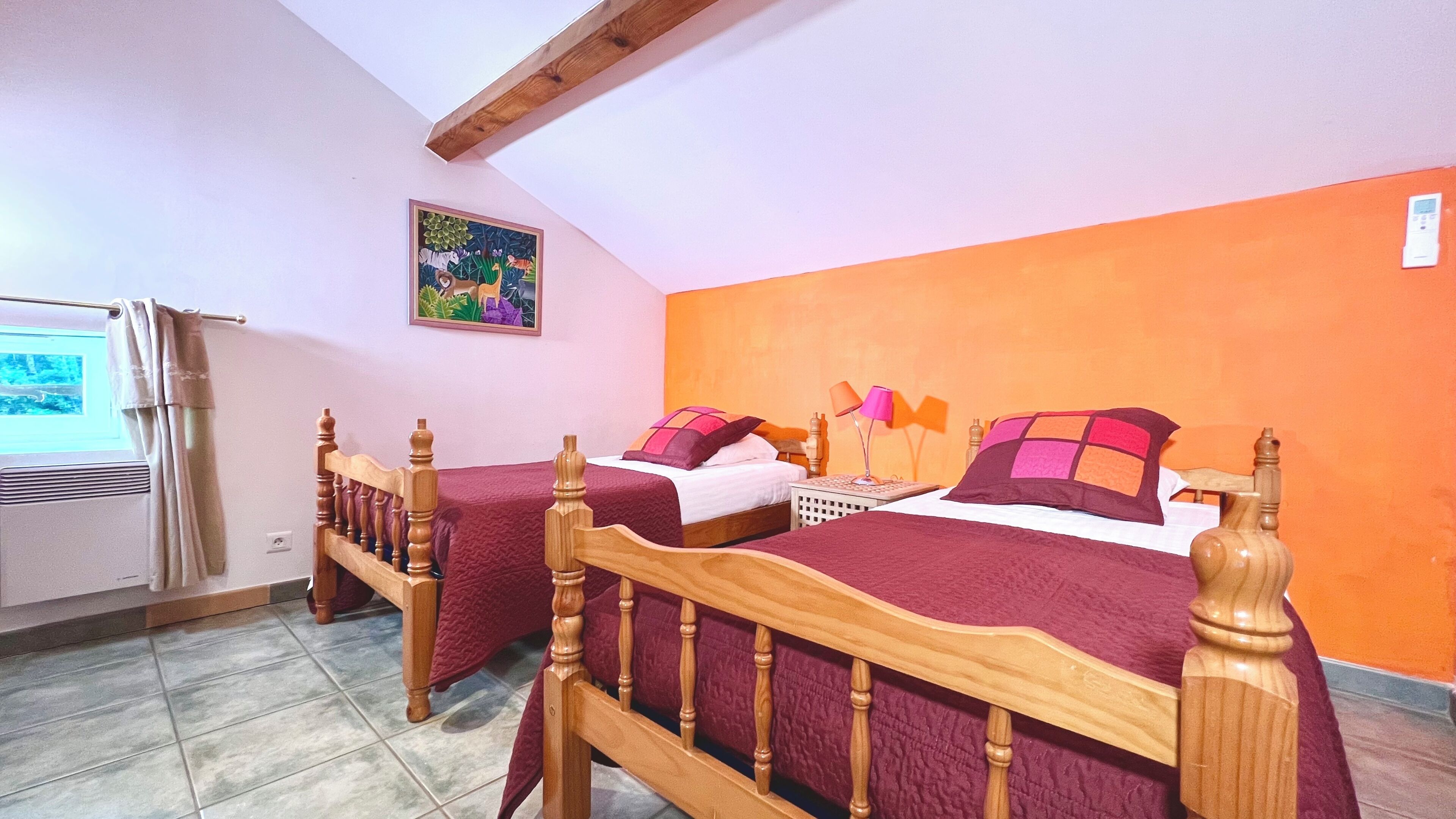 Un dormitorio con dos camas de madera, una ventana con vistas, un calentador y un cuadro en la pared.